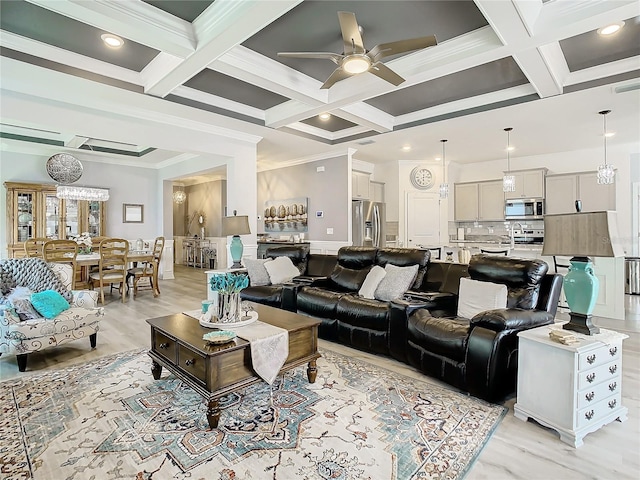 living room with ceiling fan, light wood-type flooring, crown molding, and coffered ceiling