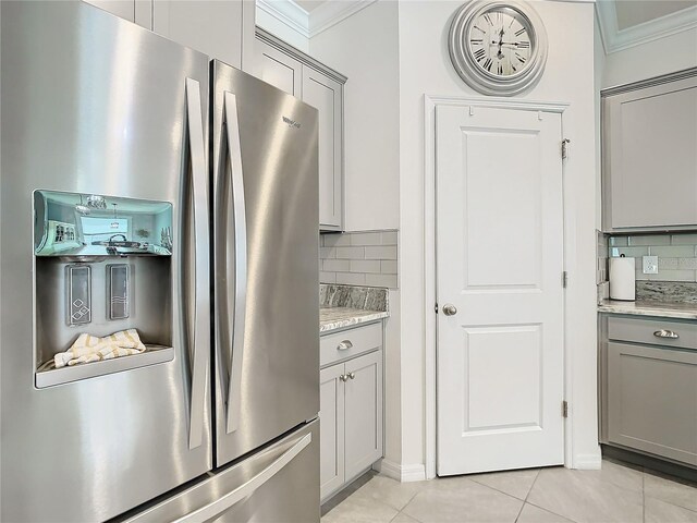 kitchen featuring decorative backsplash, stainless steel fridge, and gray cabinets