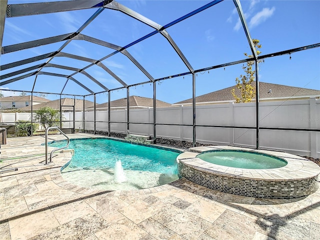 view of pool featuring pool water feature, glass enclosure, a patio area, and an in ground hot tub