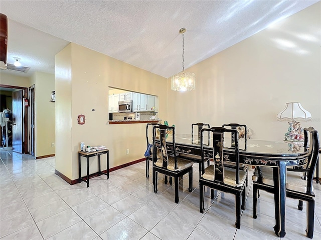 tiled dining room featuring a textured ceiling and a notable chandelier