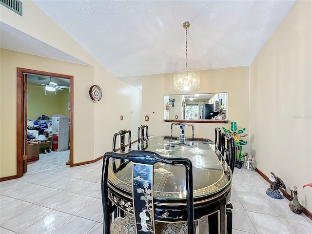 dining room featuring ceiling fan with notable chandelier, light tile patterned flooring, and lofted ceiling