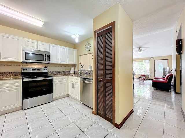 kitchen with tasteful backsplash, white cabinetry, light tile patterned floors, and stainless steel appliances