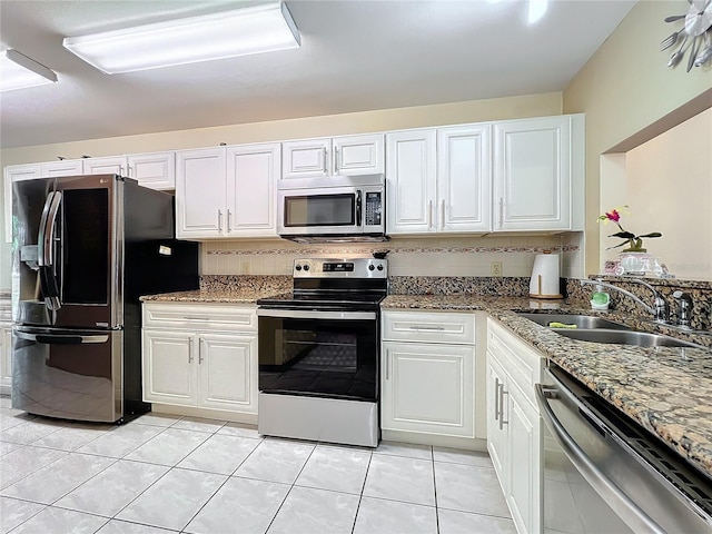 kitchen featuring white cabinets, light tile patterned floors, stainless steel appliances, and sink