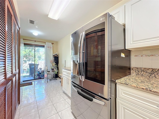 kitchen with white cabinetry, decorative backsplash, stainless steel fridge with ice dispenser, and light tile patterned floors