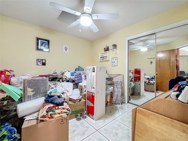 tiled bedroom featuring ceiling fan, a closet, and a textured ceiling