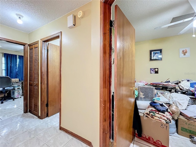 hallway featuring light tile patterned floors and a textured ceiling