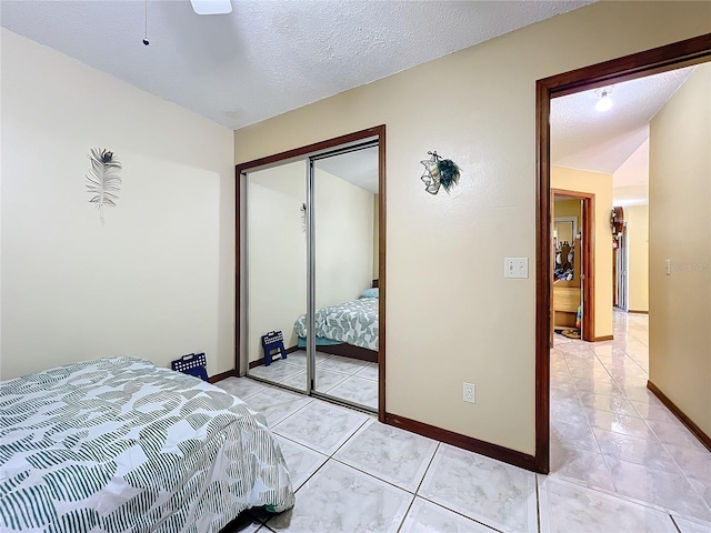 tiled bedroom featuring lofted ceiling, ceiling fan, a closet, and a textured ceiling