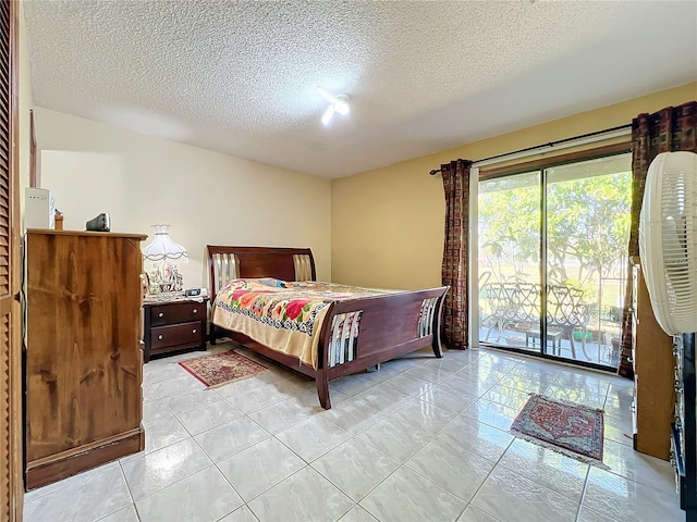 tiled bedroom featuring a textured ceiling and access to outside