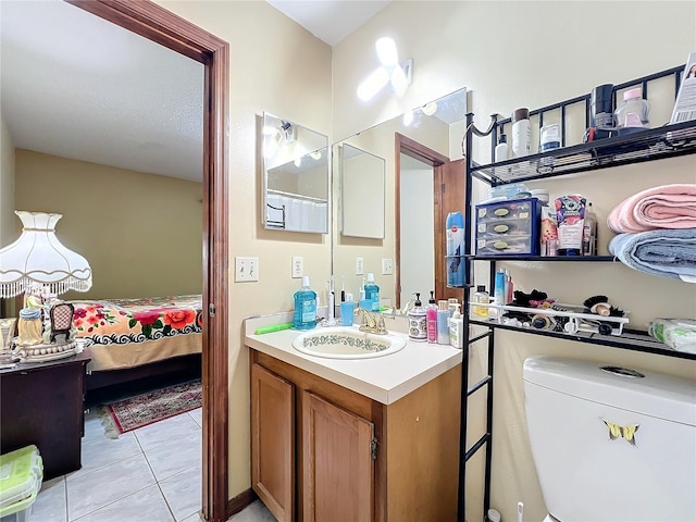 bathroom with tile patterned flooring, vanity, and toilet