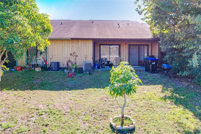 view of front of house with a front lawn and central AC unit