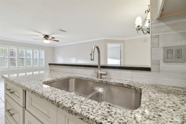 kitchen featuring sink, pendant lighting, and ornamental molding