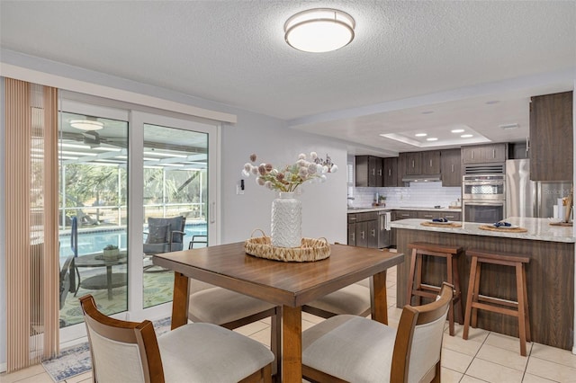 tiled dining space featuring a textured ceiling