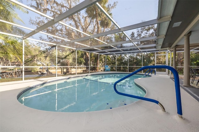 view of swimming pool featuring glass enclosure and a patio area