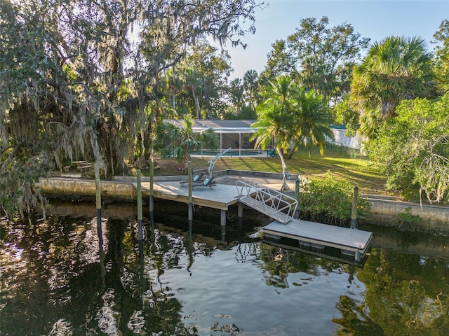 dock area featuring a water view and a lawn