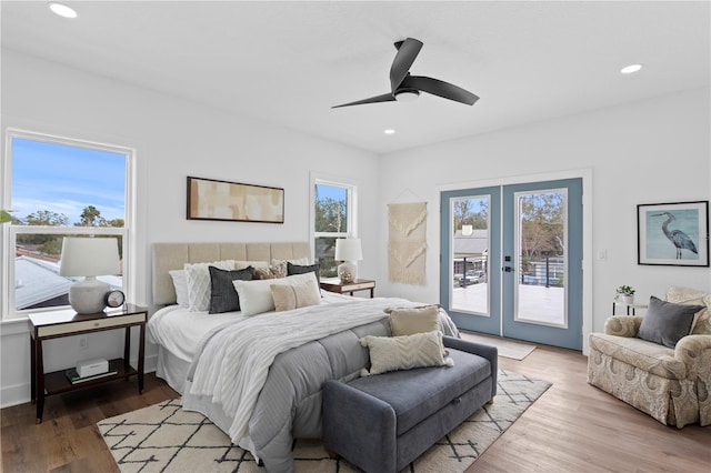 bedroom with french doors, multiple windows, wood finished floors, and access to exterior