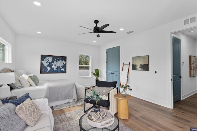 bedroom with visible vents, multiple windows, and wood finished floors