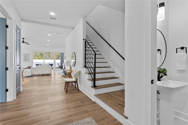 stairs featuring recessed lighting, visible vents, a textured ceiling, and wood finished floors