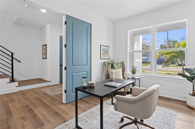 office space with baseboards and wood finished floors