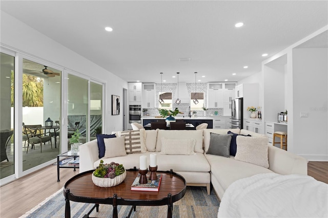 living room with a ceiling fan, wood finished floors, a wealth of natural light, and recessed lighting