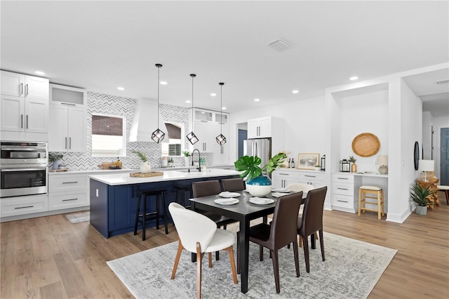 dining space with light wood-style floors, visible vents, and recessed lighting