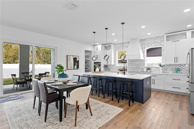 dining room featuring light wood finished floors, visible vents, and recessed lighting