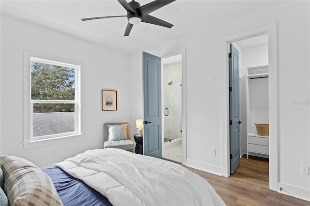 bedroom featuring a ceiling fan, wood finished floors, connected bathroom, and baseboards