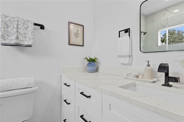 full bathroom featuring toilet, a marble finish shower, and vanity