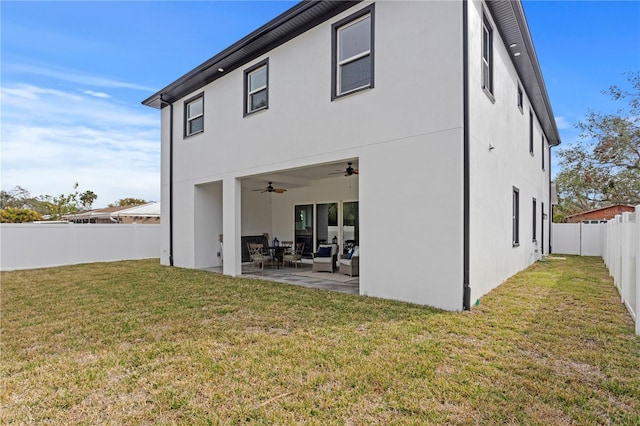 back of property featuring a lawn, a ceiling fan, a patio, a fenced backyard, and stucco siding