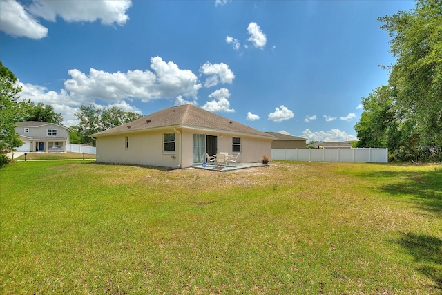 rear view of house with a patio area and a yard