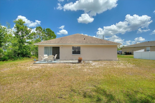 back of property with a yard and a patio