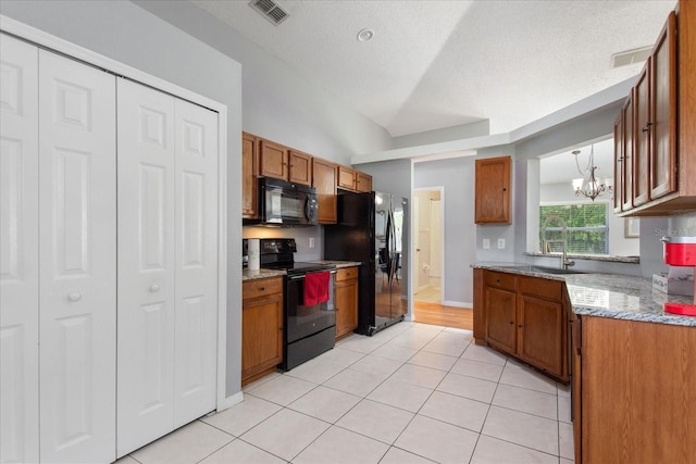 kitchen featuring light stone counters, a chandelier, a textured ceiling, light tile patterned floors, and black appliances