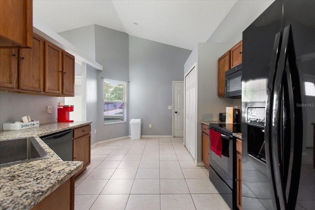 kitchen featuring light stone countertops, light tile patterned floors, black appliances, and high vaulted ceiling