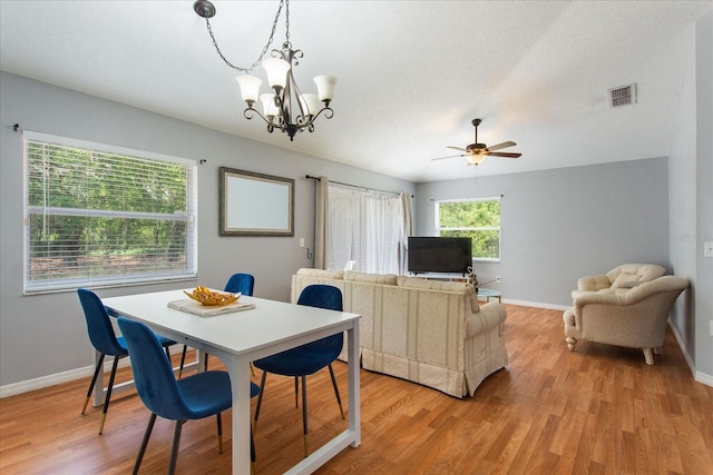 dining room featuring a textured ceiling, ceiling fan with notable chandelier, and light wood-type flooring