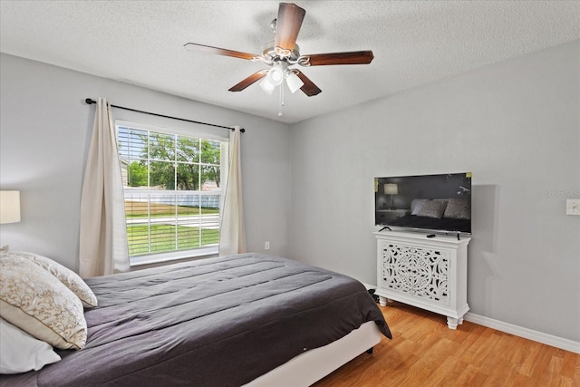 bedroom featuring hardwood / wood-style floors, a textured ceiling, and ceiling fan