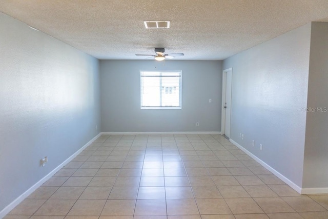 empty room featuring ceiling fan, a textured ceiling, and light tile patterned flooring