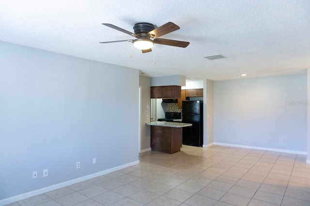 unfurnished living room with a textured ceiling, ceiling fan, and light tile patterned floors