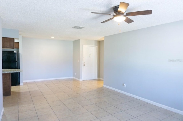 tiled empty room with a textured ceiling and ceiling fan