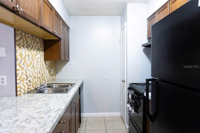 kitchen featuring sink, black appliances, a textured ceiling, light tile patterned floors, and backsplash