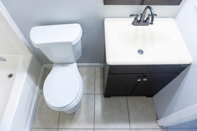 bathroom featuring toilet, vanity, and tile patterned flooring