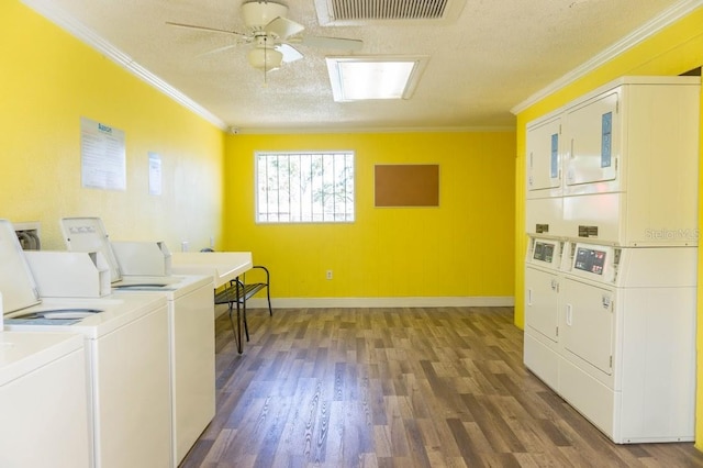 laundry room with stacked washer and clothes dryer, dark hardwood / wood-style floors, and crown molding