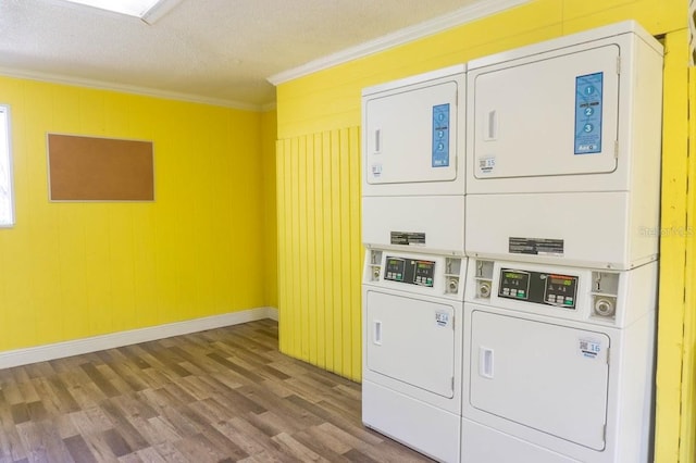 laundry room with crown molding, hardwood / wood-style floors, a textured ceiling, and stacked washer / drying machine