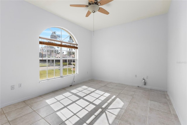 tiled empty room with ceiling fan and a wealth of natural light