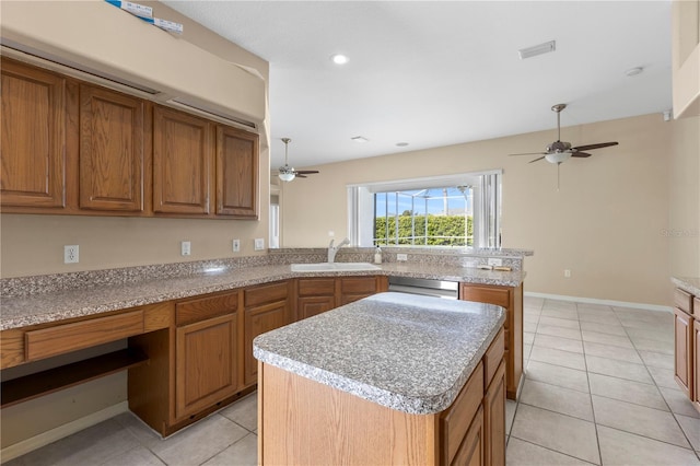 kitchen with stainless steel dishwasher, ceiling fan, sink, light tile patterned floors, and a kitchen island