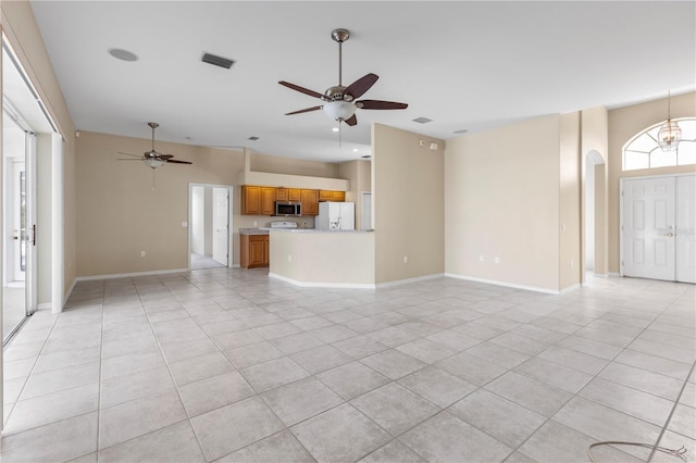 unfurnished living room featuring ceiling fan with notable chandelier and light tile patterned flooring