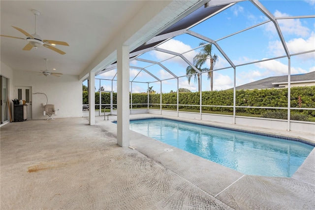 view of pool with a patio, glass enclosure, and ceiling fan