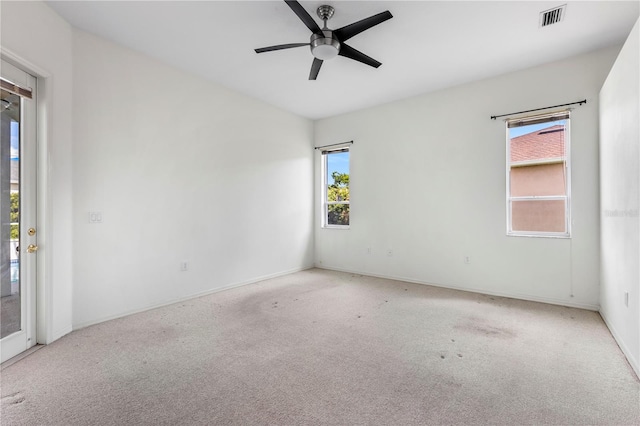 unfurnished room with light carpet, a wealth of natural light, and ceiling fan