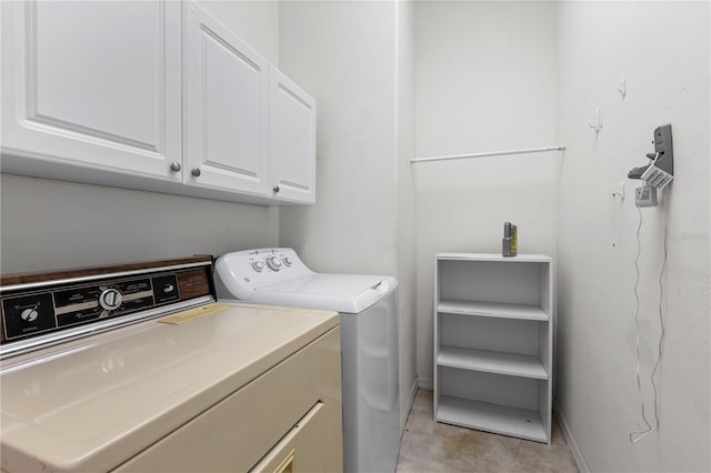 laundry area featuring washer and clothes dryer and cabinets