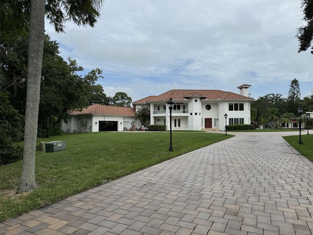 mediterranean / spanish home featuring a front lawn