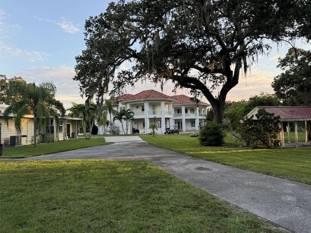 mediterranean / spanish-style house with a lawn and central AC