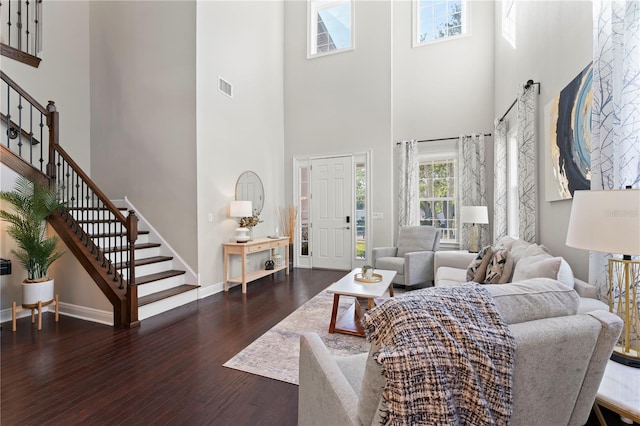 living room featuring a high ceiling and dark hardwood / wood-style flooring